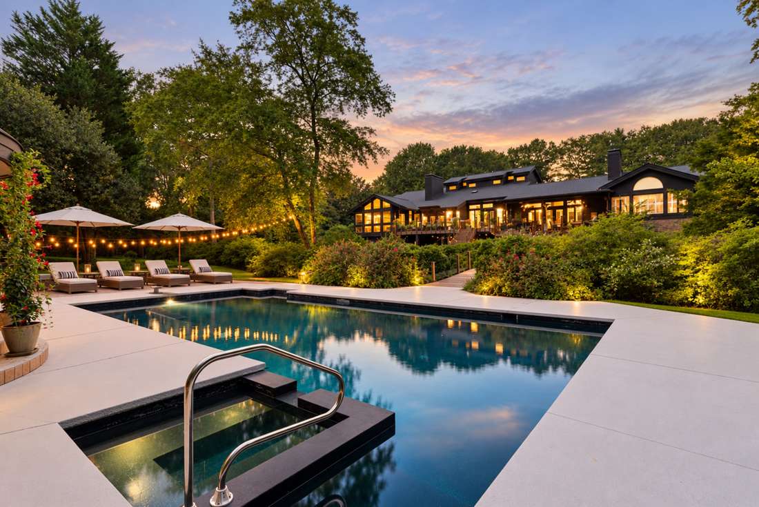 The pool at twilight, string lights doubled in the water
