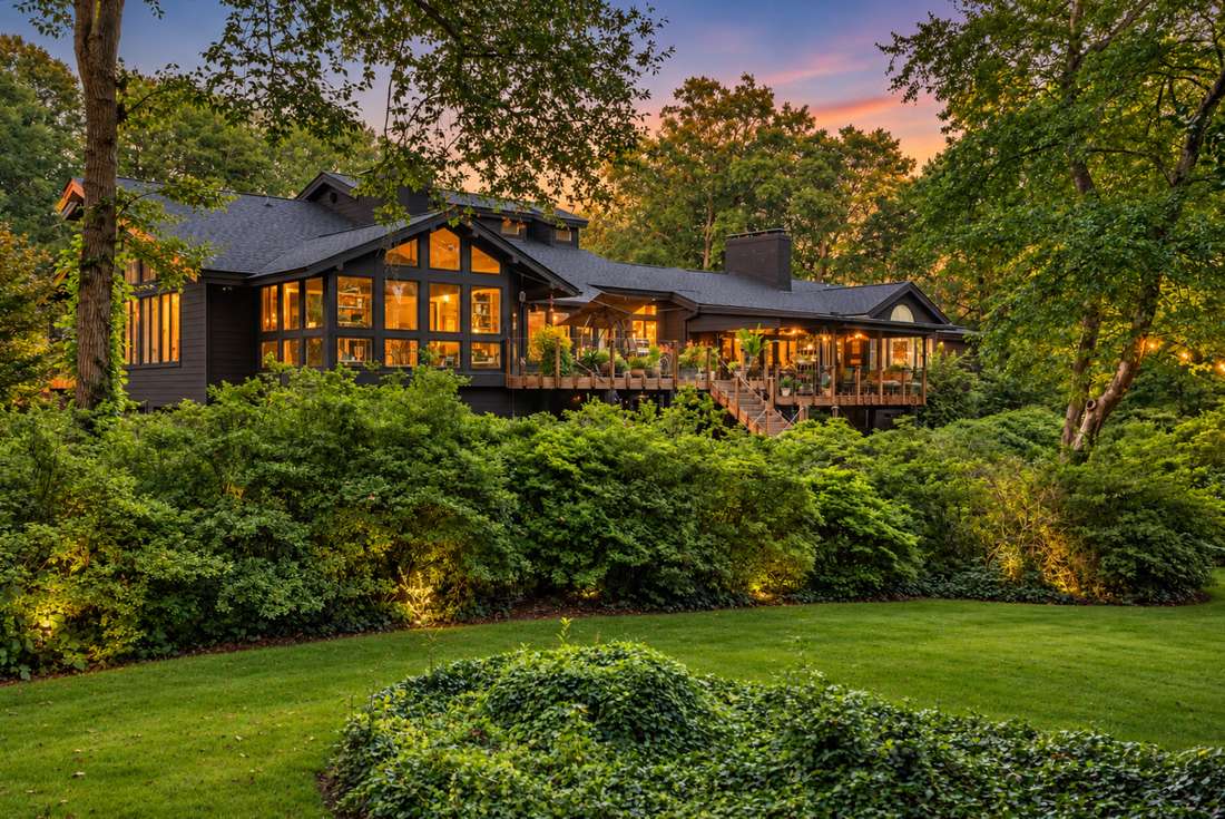 Side elevation at twilight, the glass wall lit